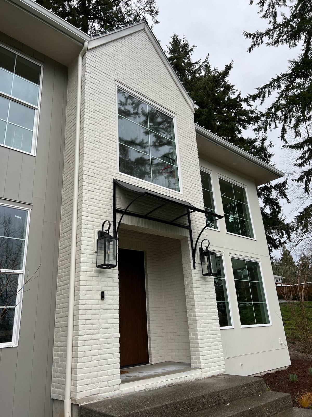 Custom steel entry awning with curved brackets by Cascade Mobile Welding