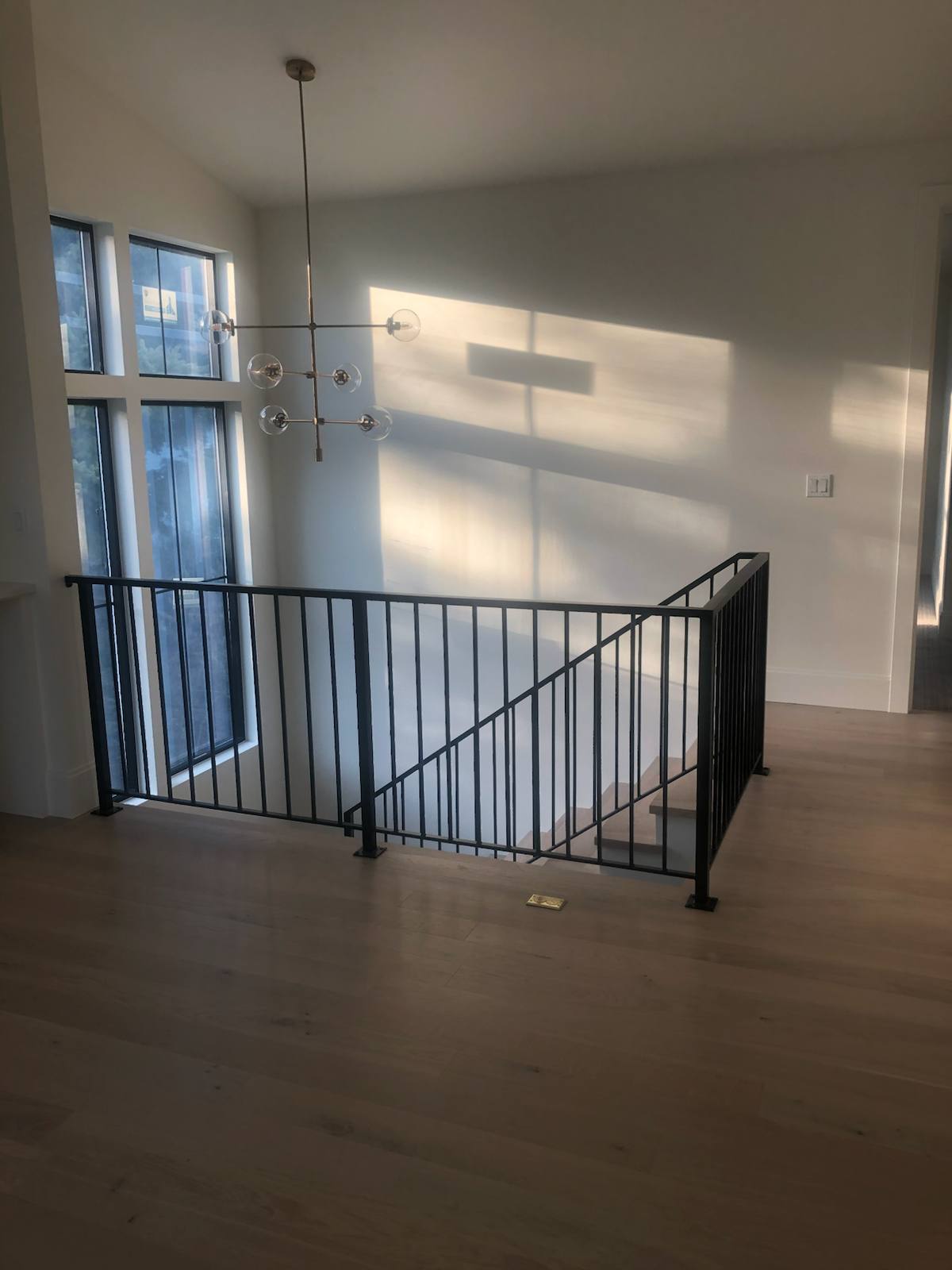 Black vertical-picket metal guardrail at an upstairs landing — custom built and installed in Portland, OR