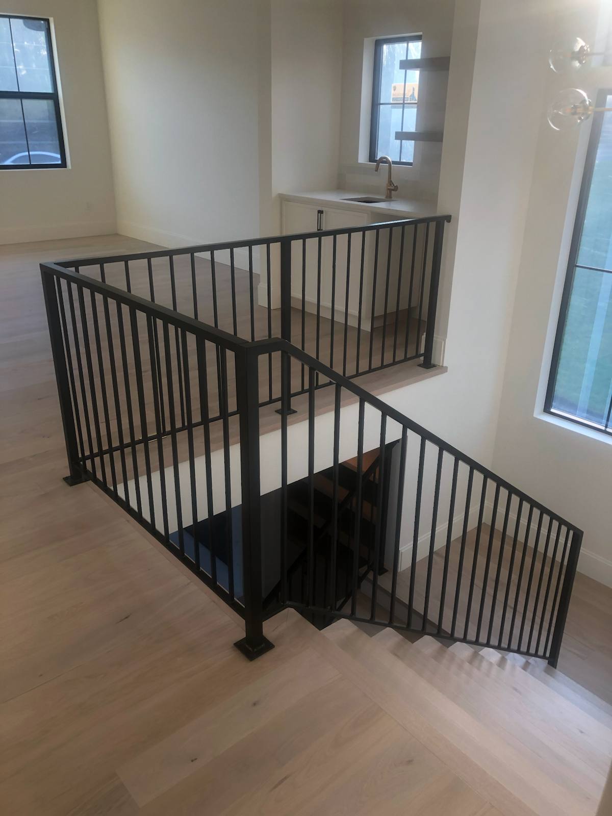 Black vertical-picket metal stair railing in a Portland-area home