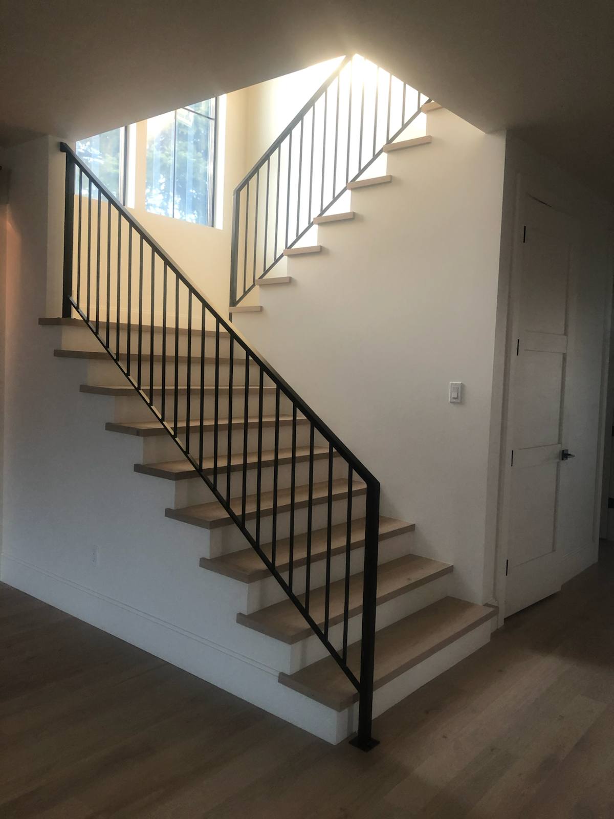 Black vertical-picket metal stair railing — measured, welded and installed on site