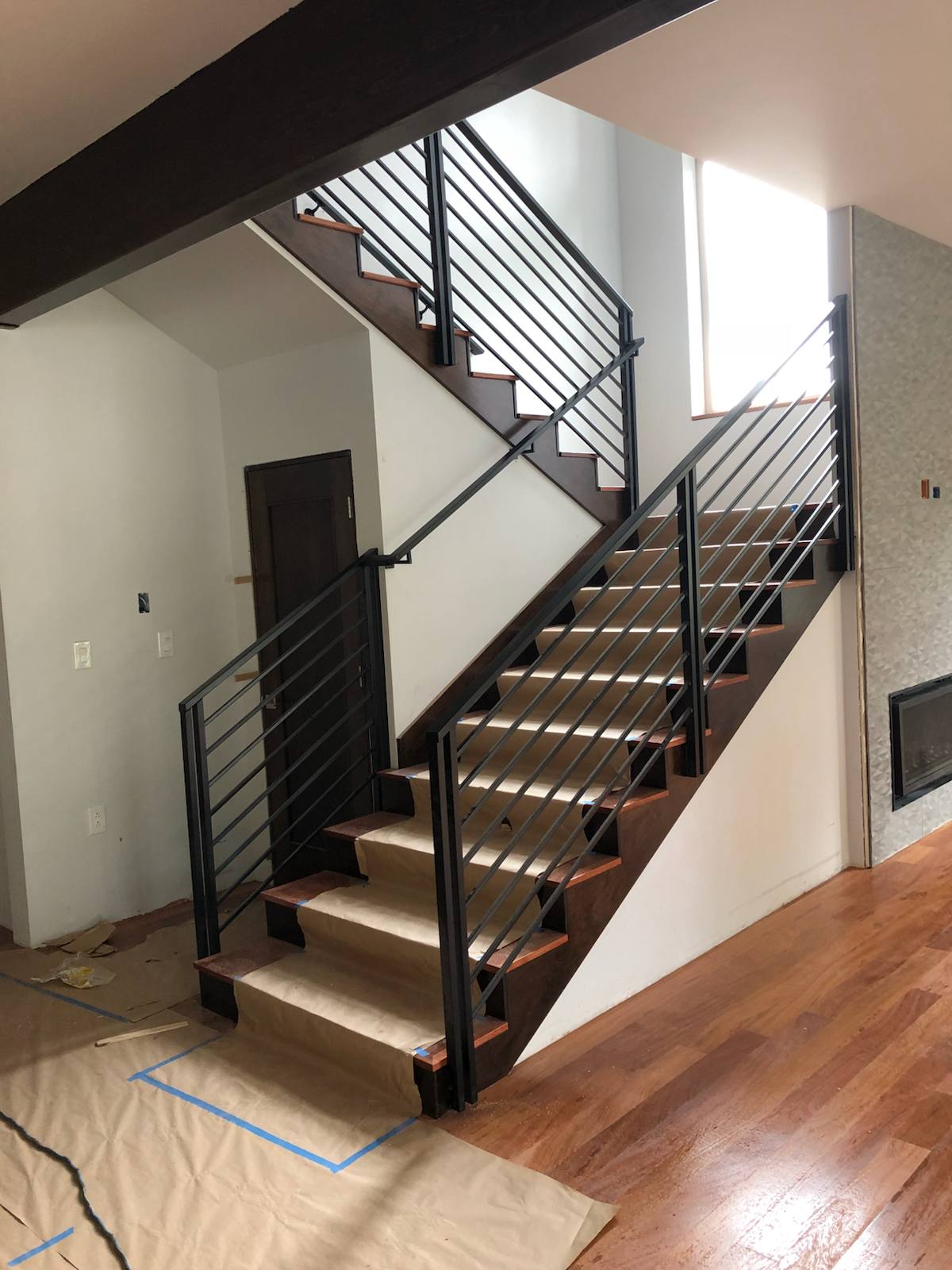 Modern horizontal-bar metal stair railing by Cascade Mobile Welding