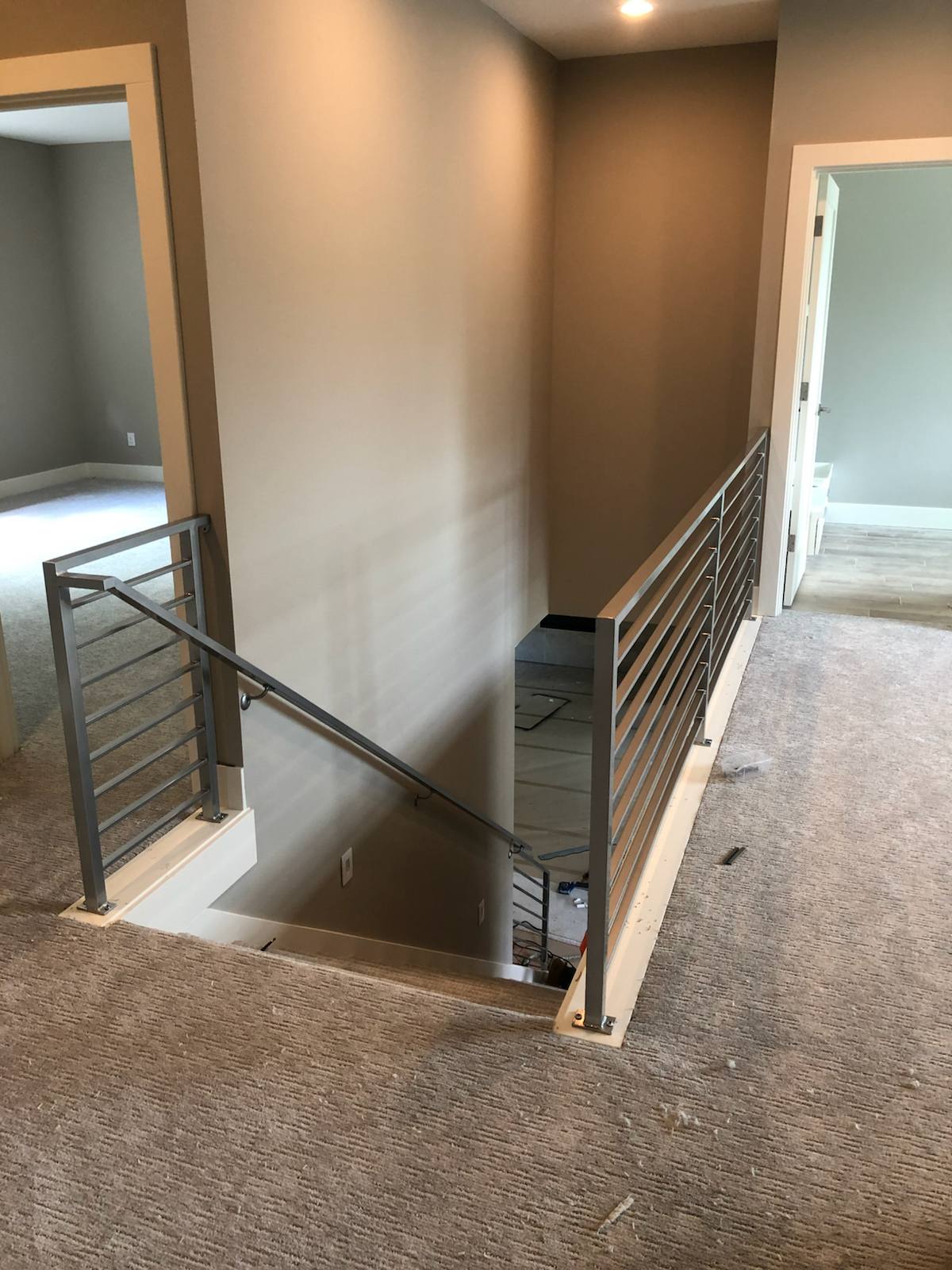Modern horizontal-bar metal guardrail at an upstairs landing by Cascade Mobile Welding