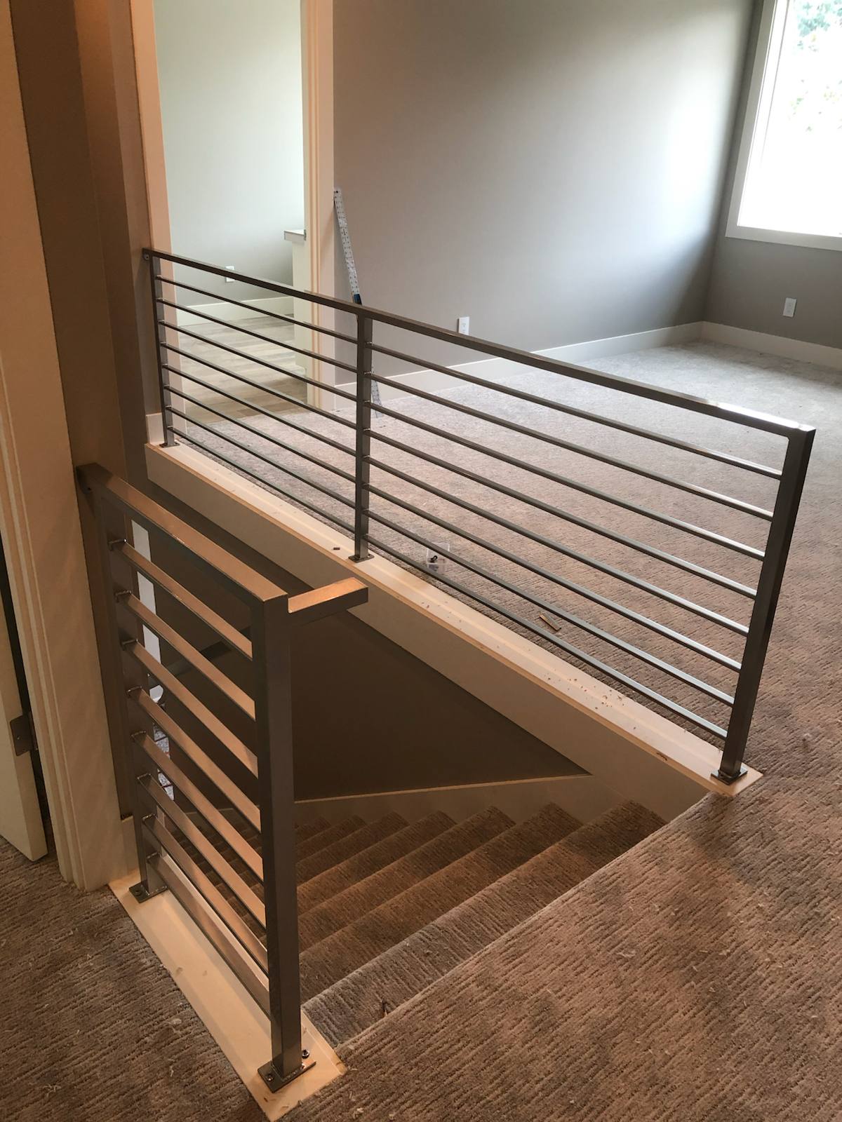 Modern horizontal-bar metal guardrail at an upstairs landing — measured, welded and installed on site