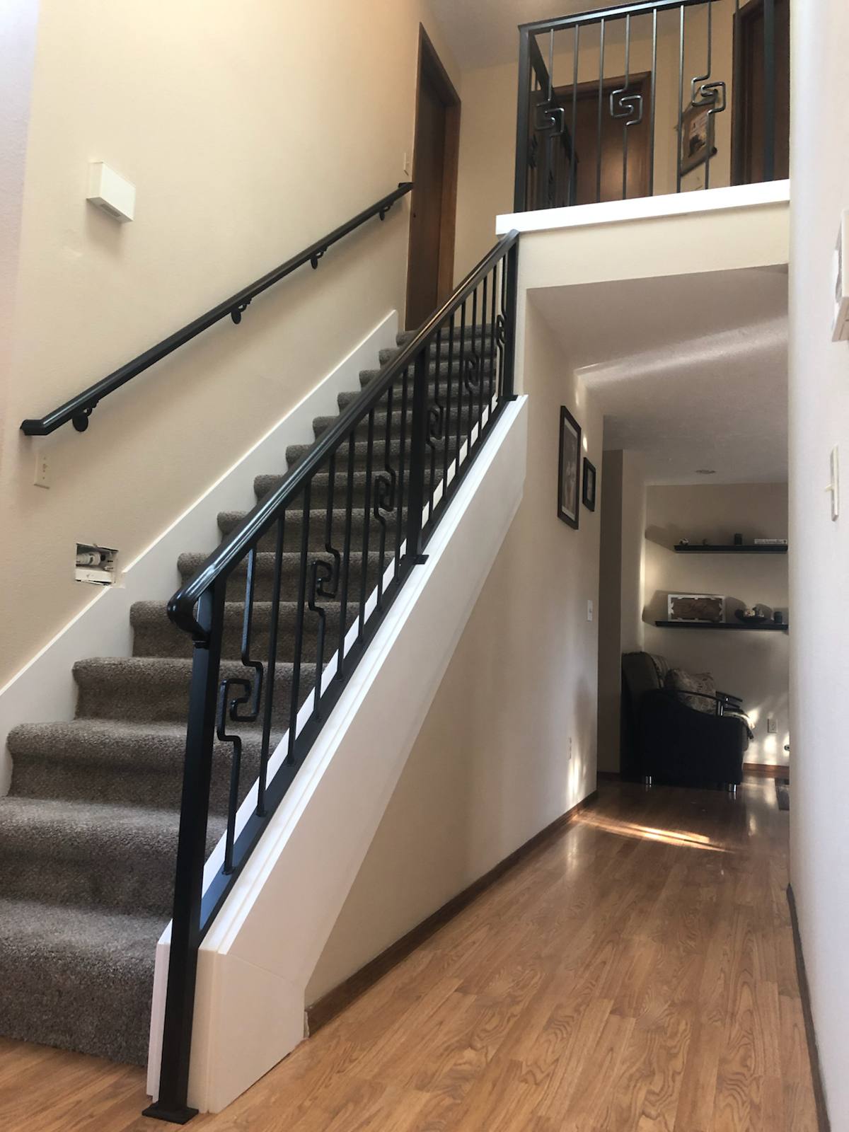Black vertical-picket metal stair railing in a Portland-area home