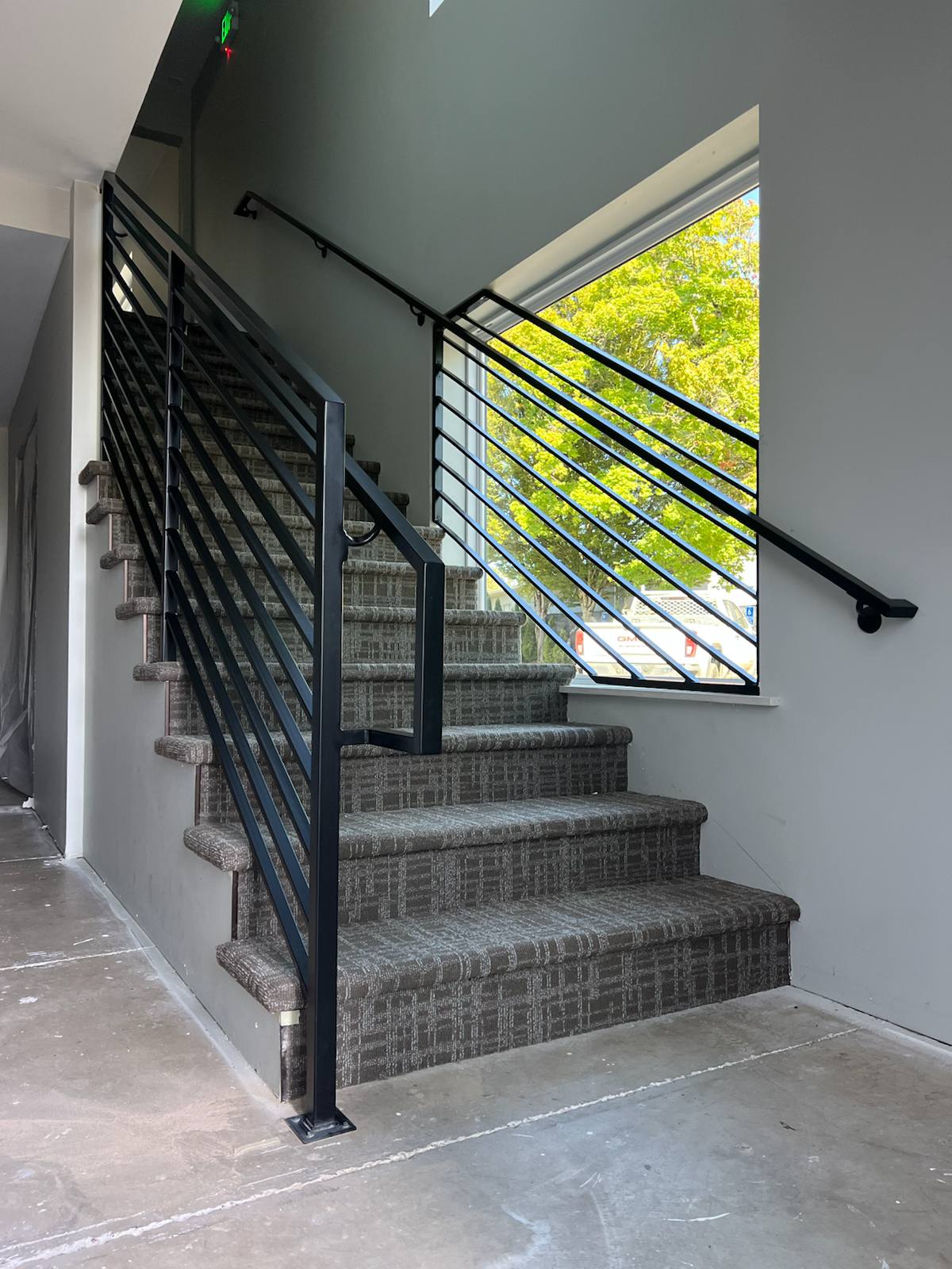 Black vertical-picket metal stair railing — custom metal railing, Portland