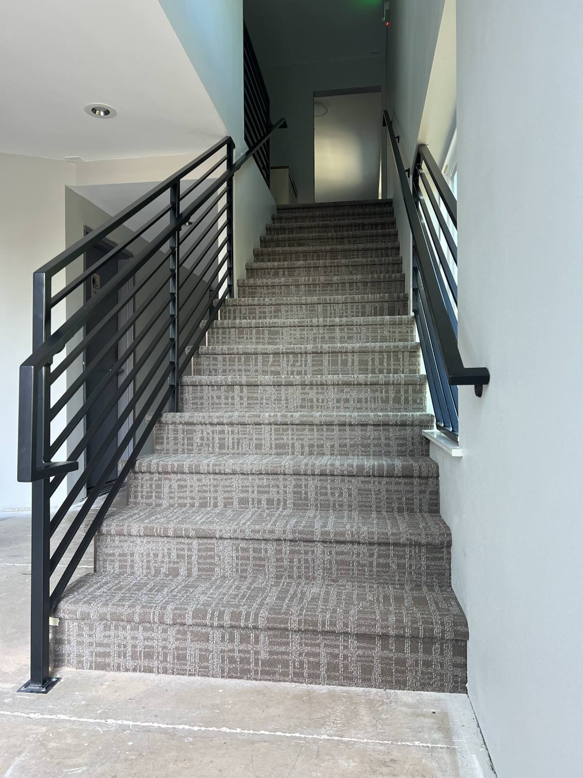 Black vertical-picket metal stair railing — custom built and installed in Portland, OR