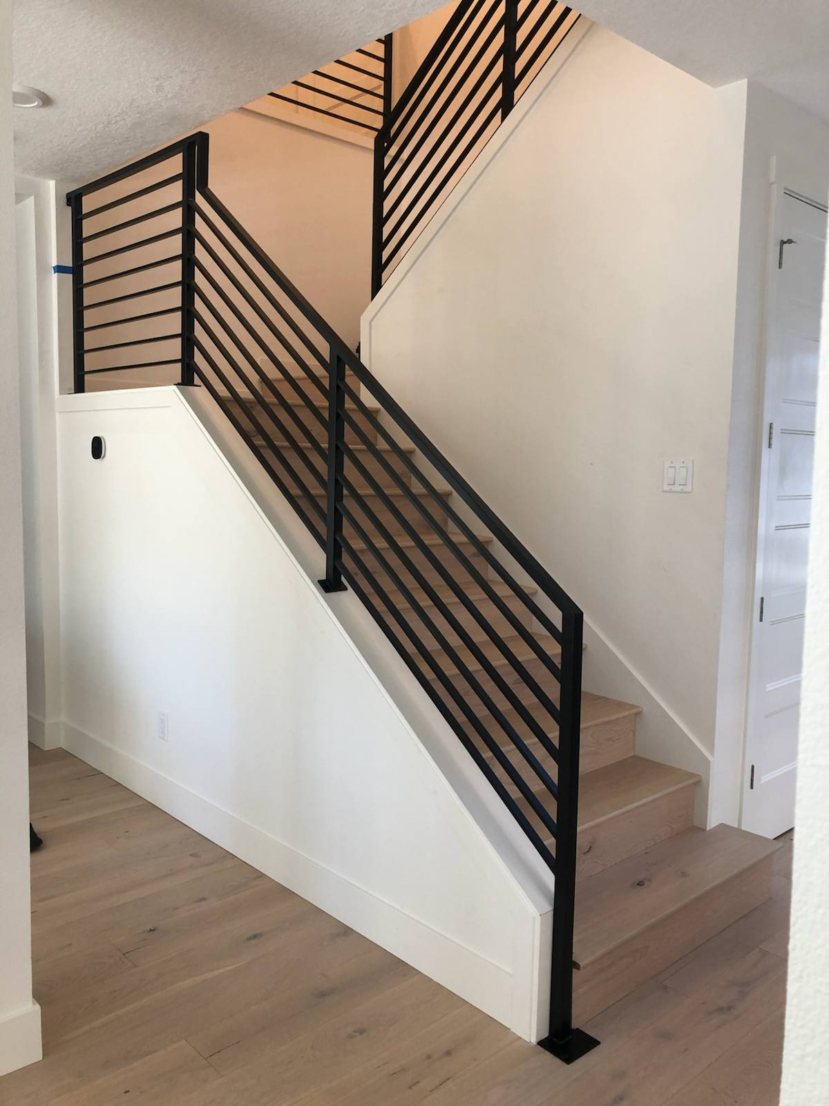 Black vertical-picket metal stair railing — measured, welded and installed on site