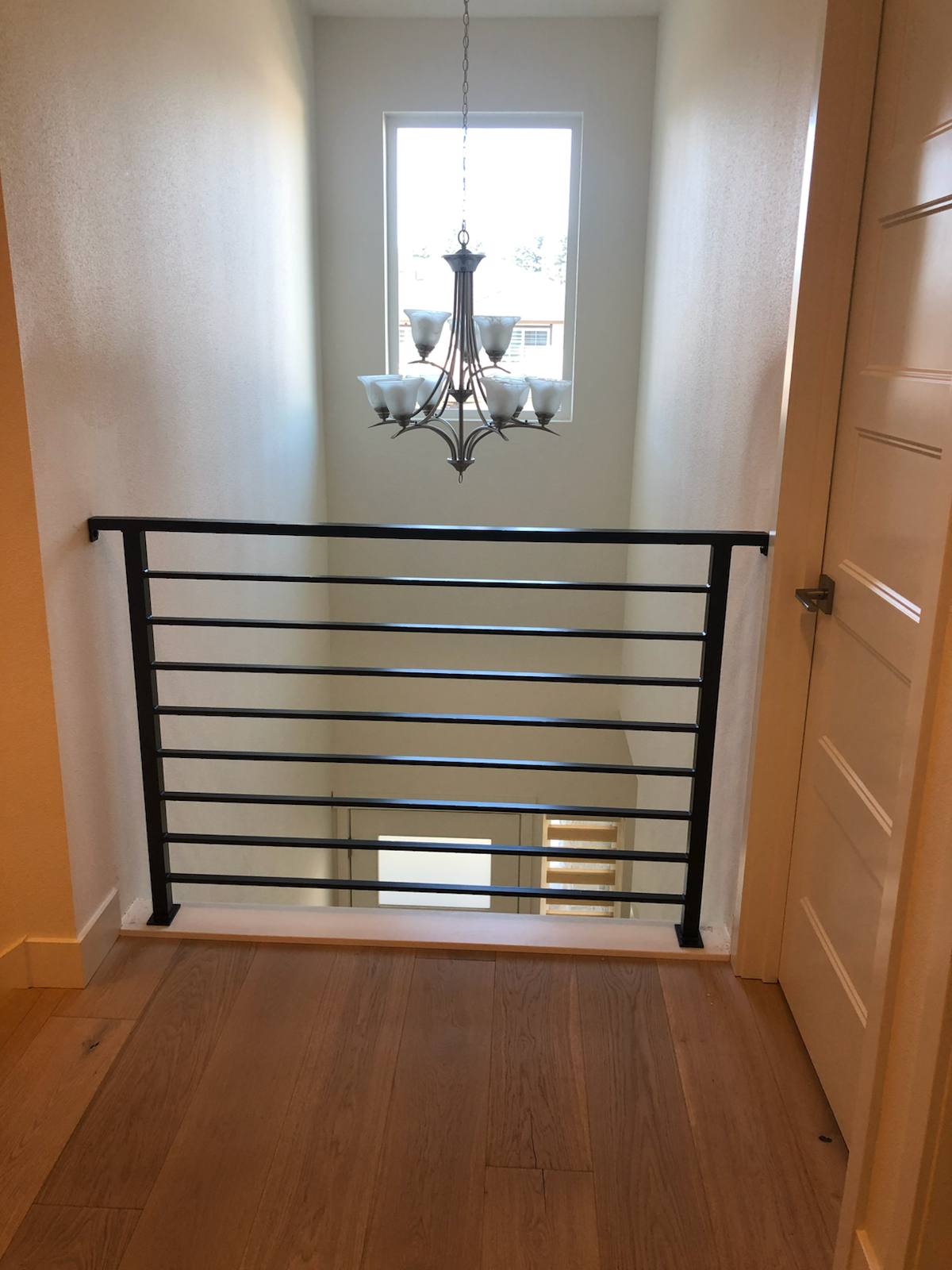 Modern horizontal-bar metal guardrail at an upstairs landing in a Portland-area home