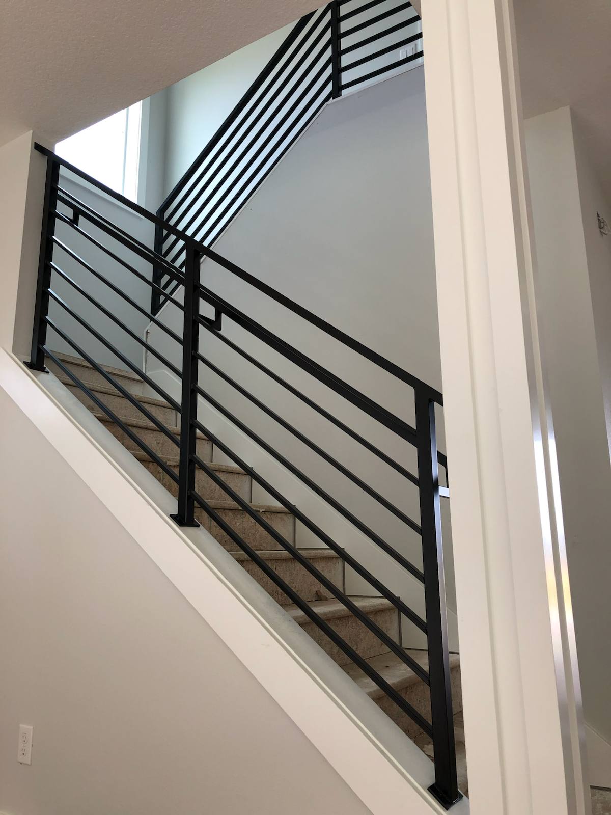 Modern horizontal-bar metal stair railing by Cascade Mobile Welding