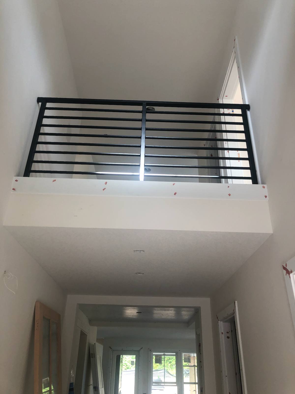 Modern horizontal-bar metal guardrail at an upstairs landing — custom built and installed in Portland, OR