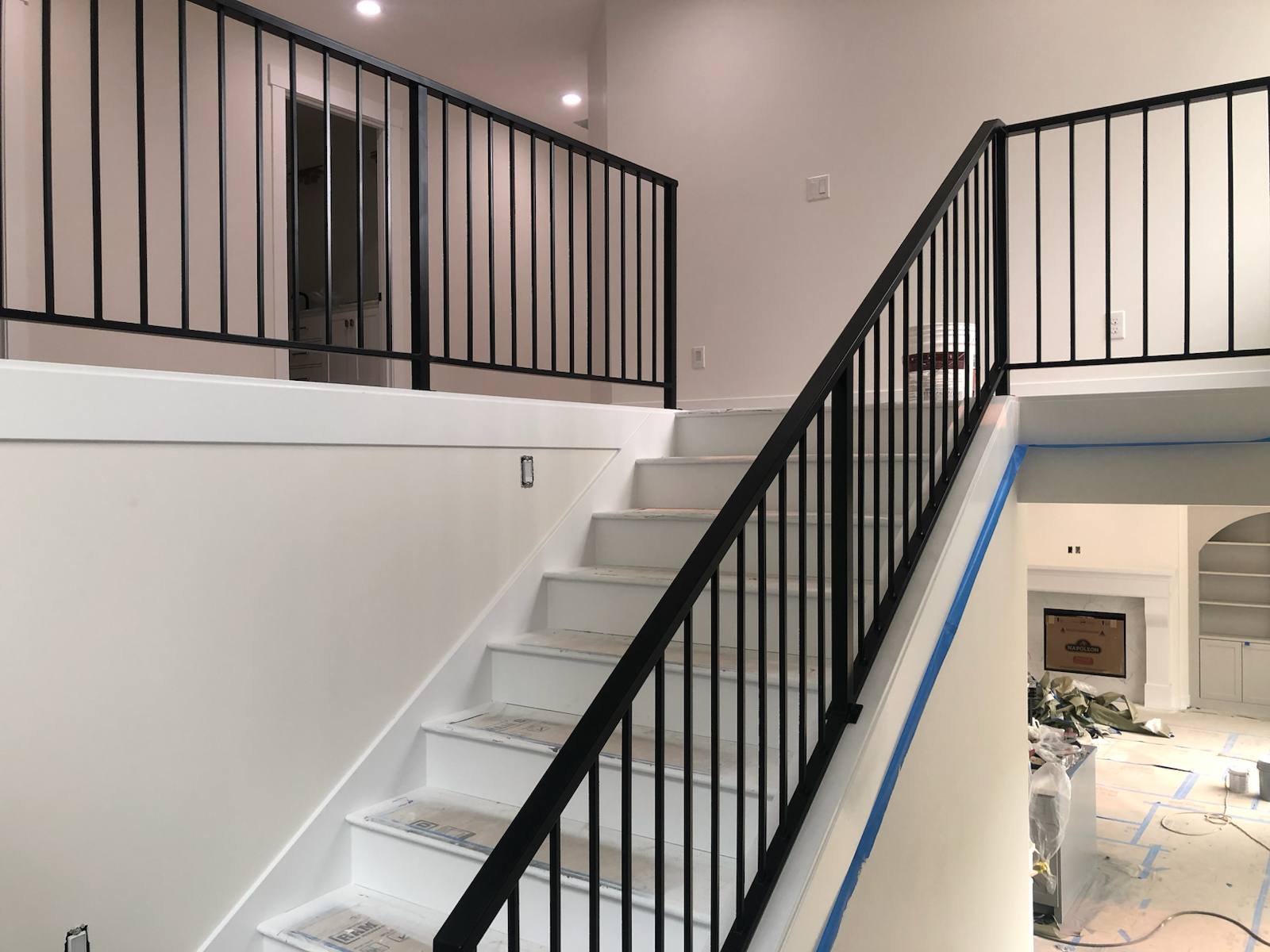 Black vertical-picket metal stair railing in a Portland-area home