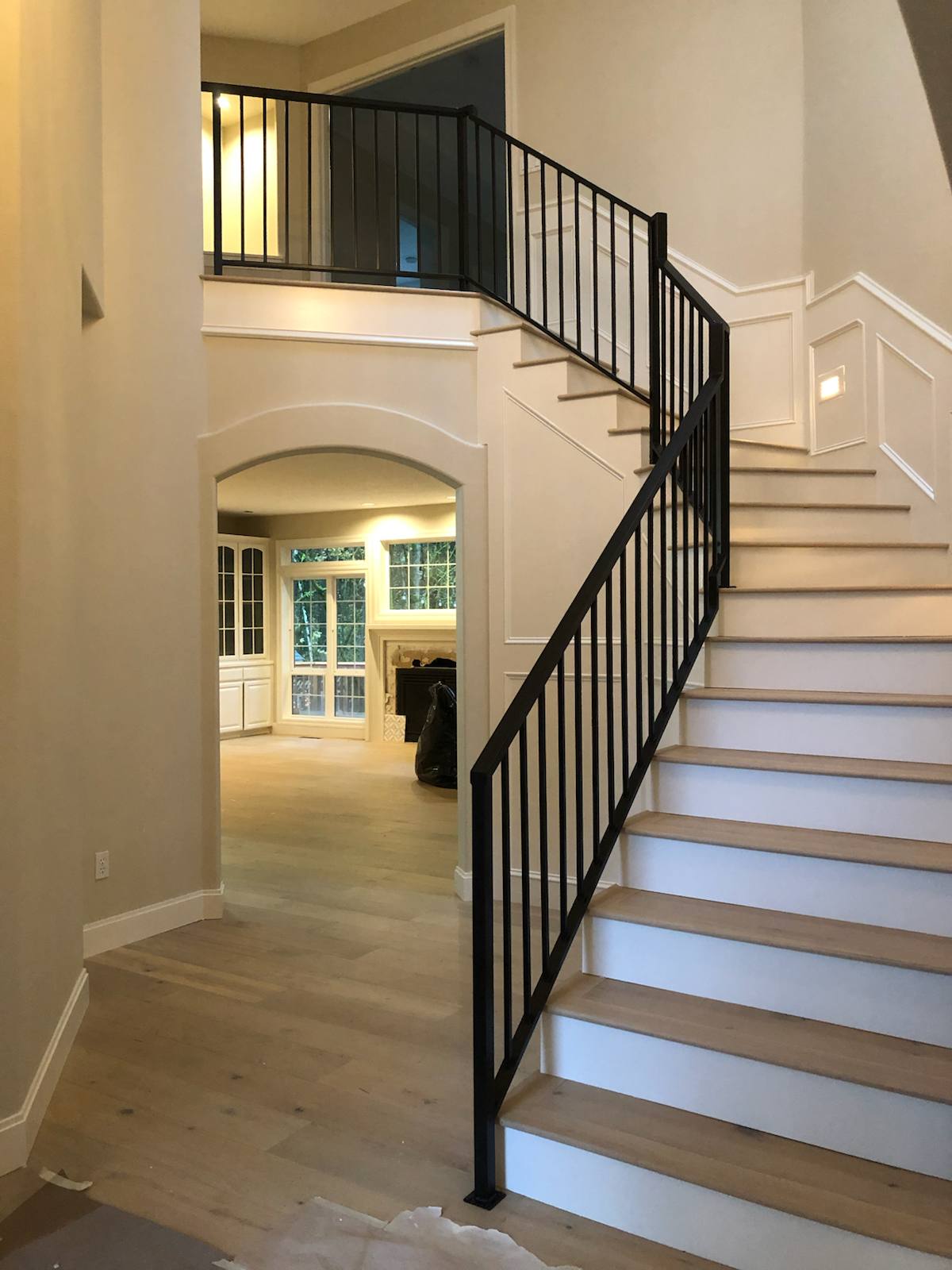 Black vertical-picket metal stair railing by Cascade Mobile Welding