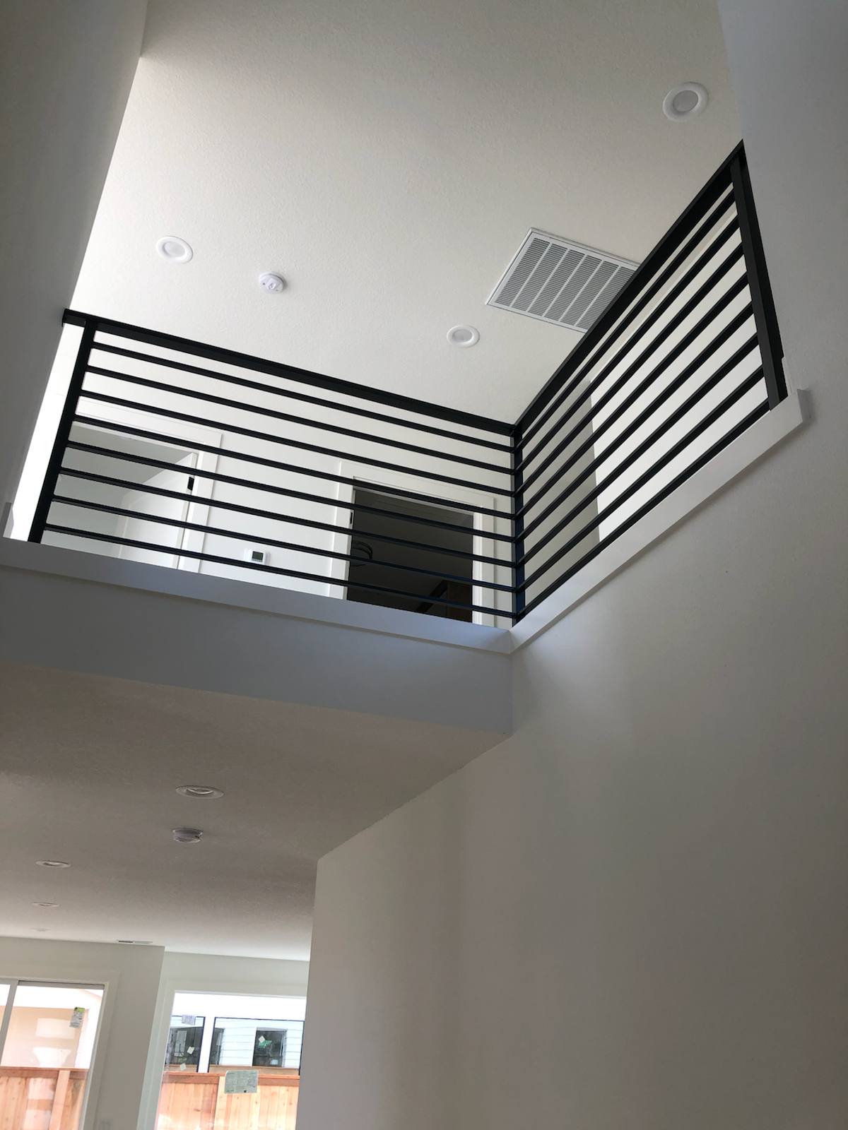 Modern horizontal-bar metal guardrail at an upstairs landing — custom metal railing, Portland