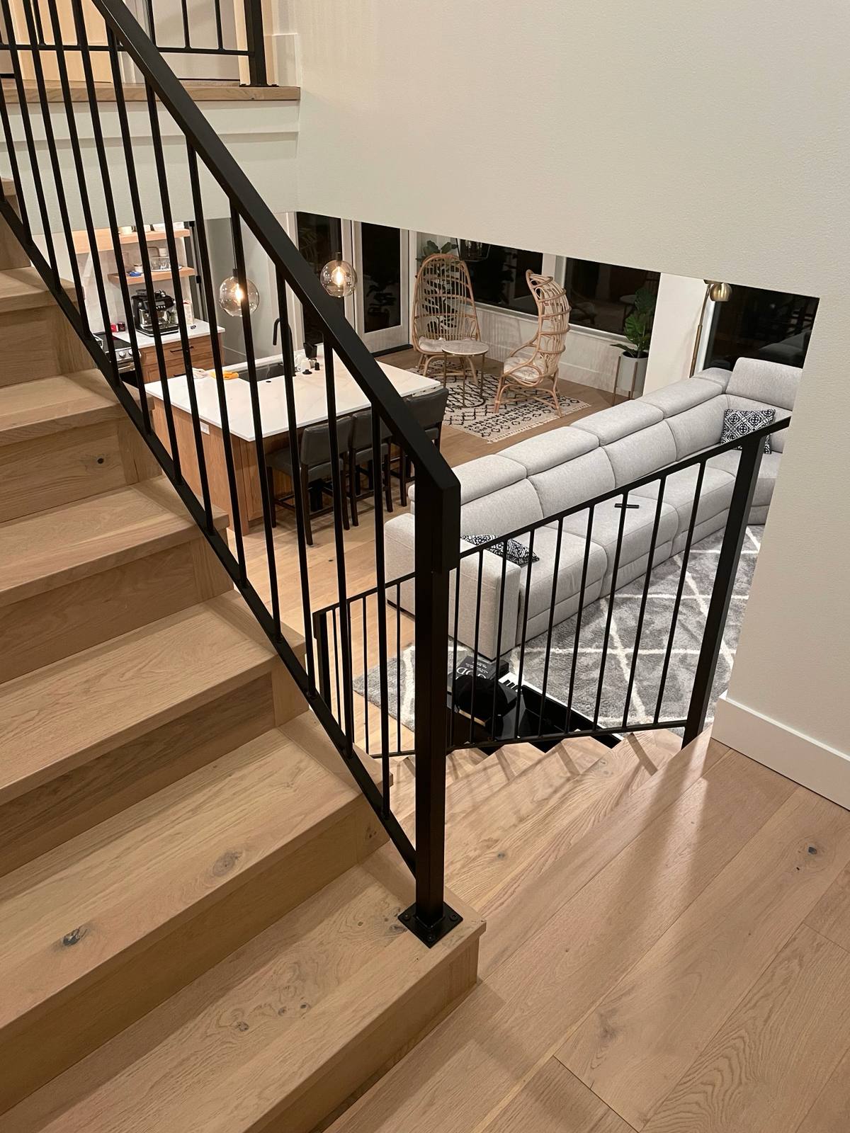 Black vertical-picket metal stair railing by Cascade Mobile Welding