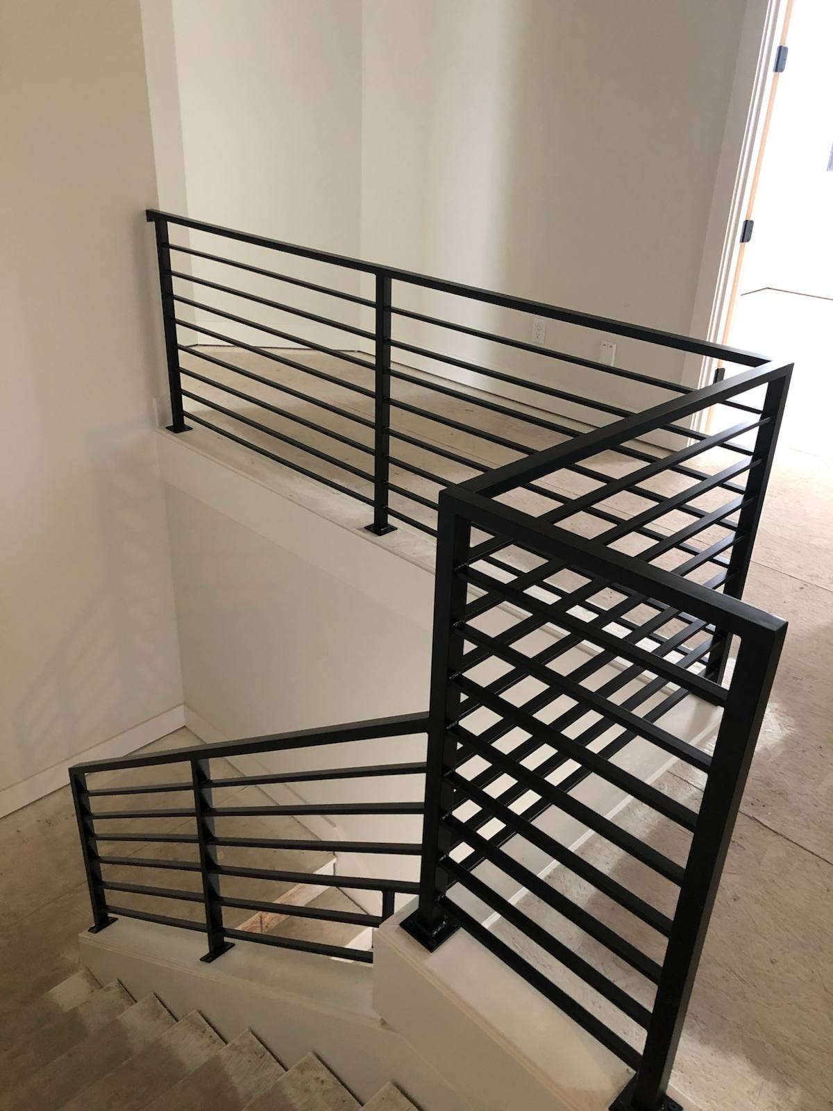 Modern horizontal-bar metal stair railing by Cascade Mobile Welding