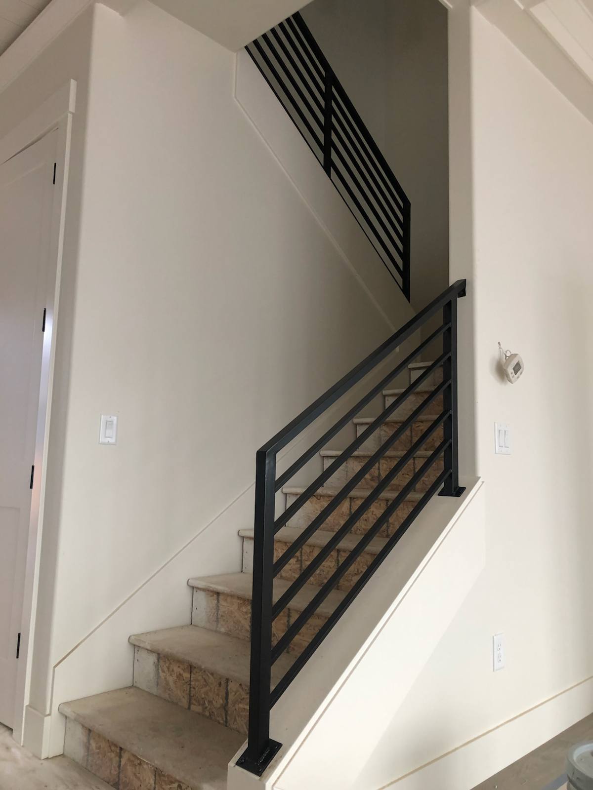 Black vertical-picket metal stair railing — measured, welded and installed on site