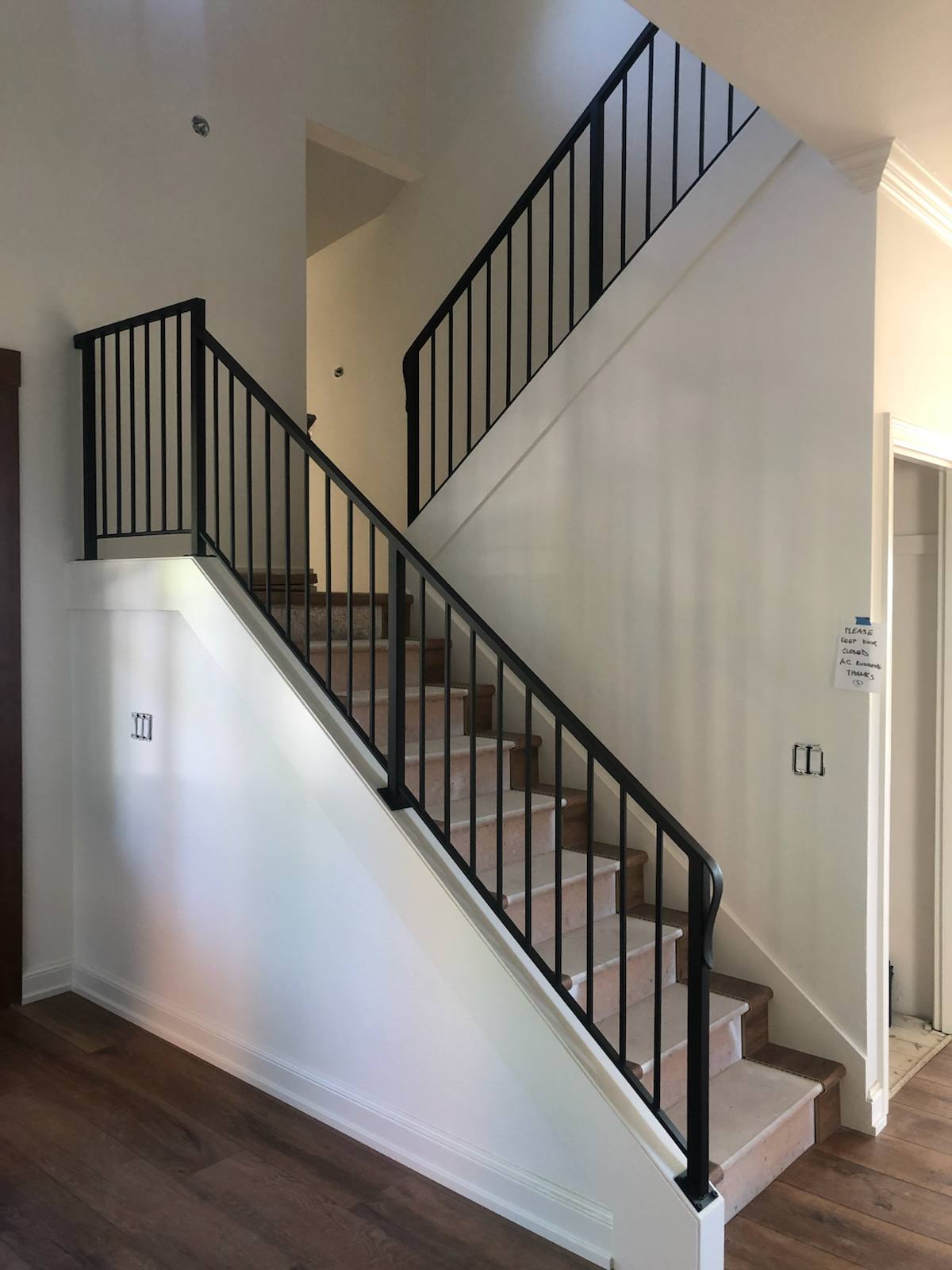 Black vertical-picket metal stair railing — measured, welded and installed on site