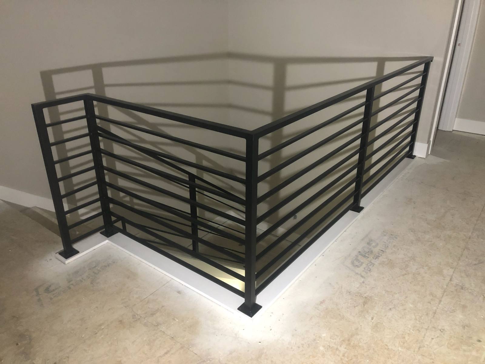 Modern horizontal-bar metal guardrail at an upstairs landing by Cascade Mobile Welding
