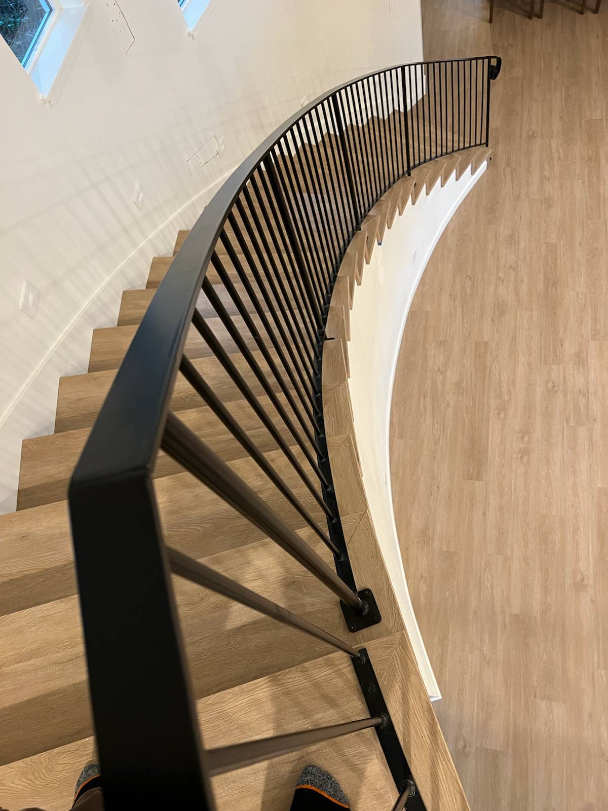 Curved custom metal staircase railing in a Portland-area home
