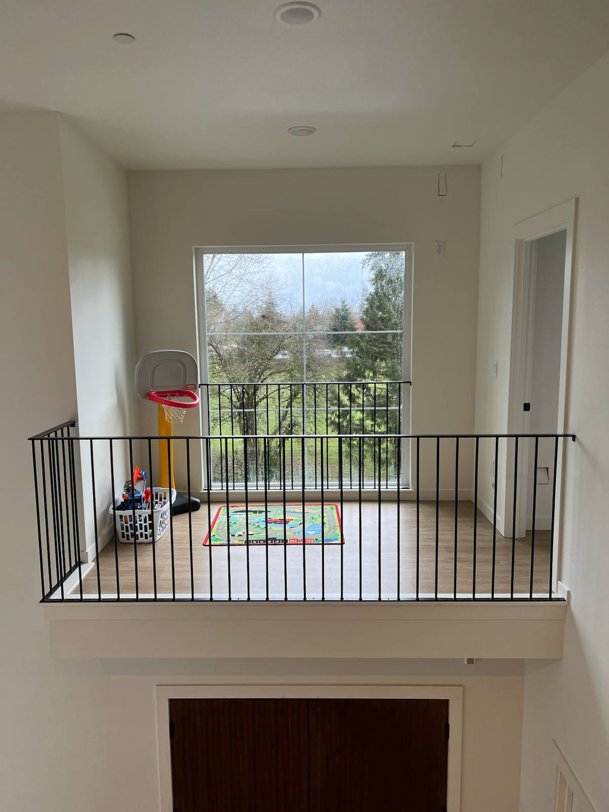 Black metal balcony railing overlooking a two-story entry — measured, welded and installed on site