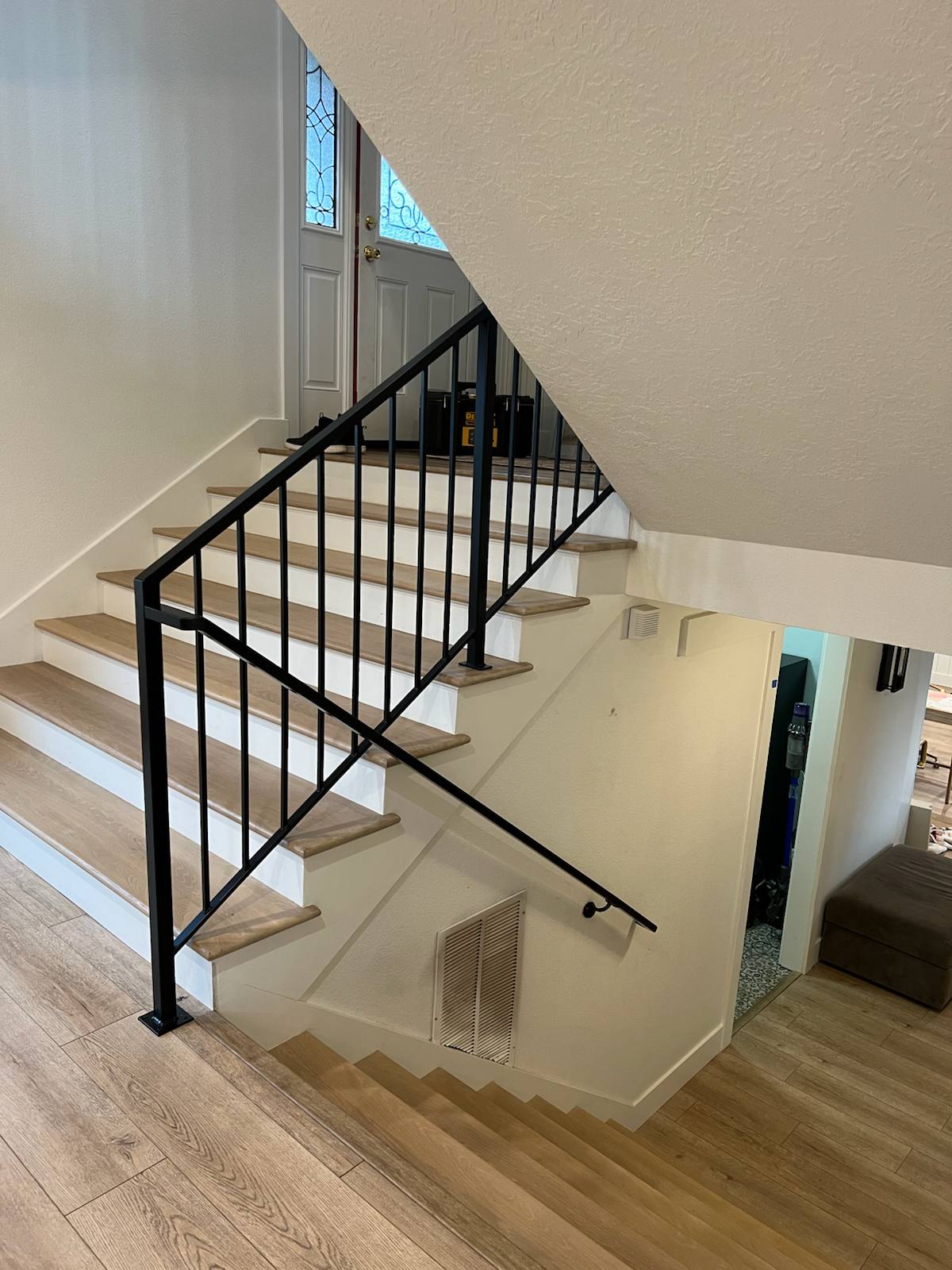 Black vertical-picket metal stair railing — measured, welded and installed on site