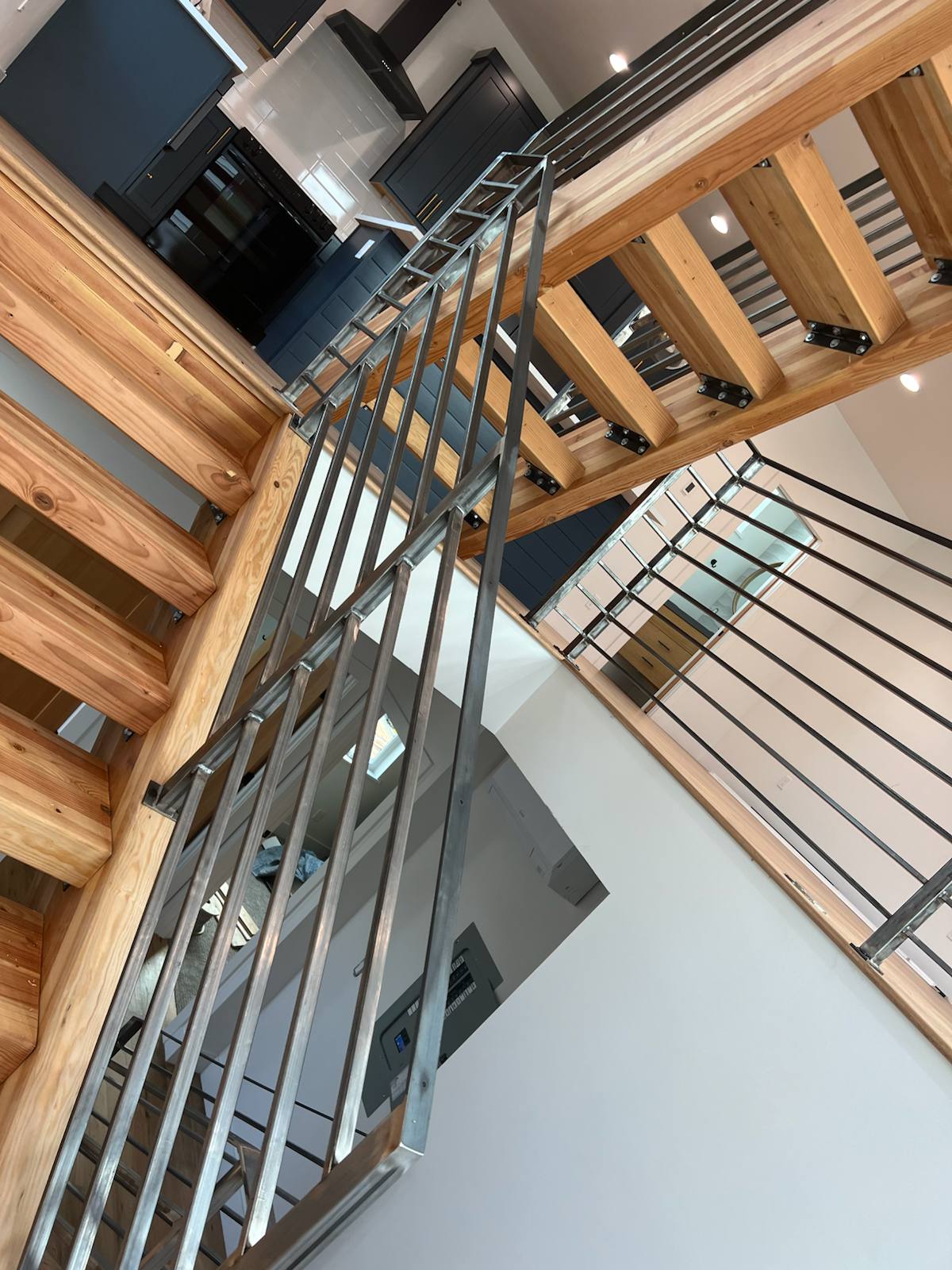 Horizontal-bar metal railing on an open-riser wood staircase — custom metal railing, Portland