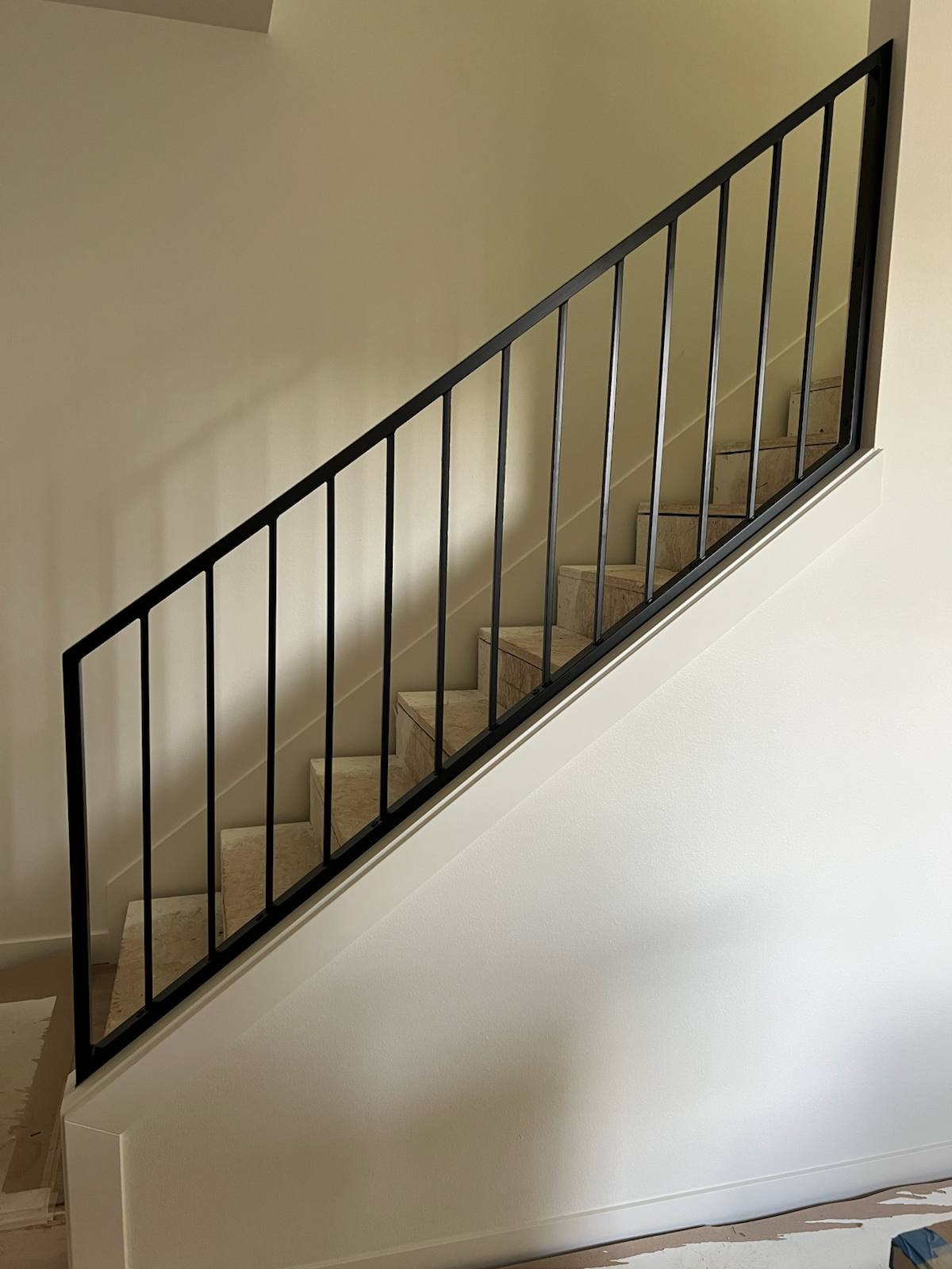 Black vertical-picket metal stair railing — measured, welded and installed on site