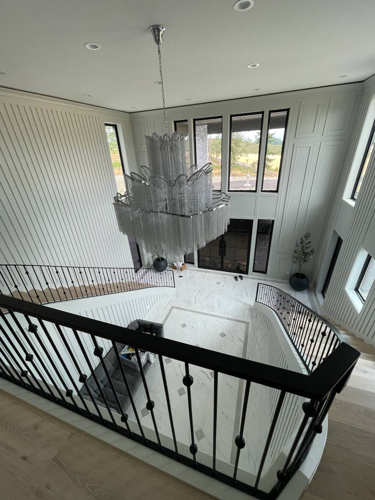 Black metal balcony railing overlooking a two-story entry by Cascade Mobile Welding