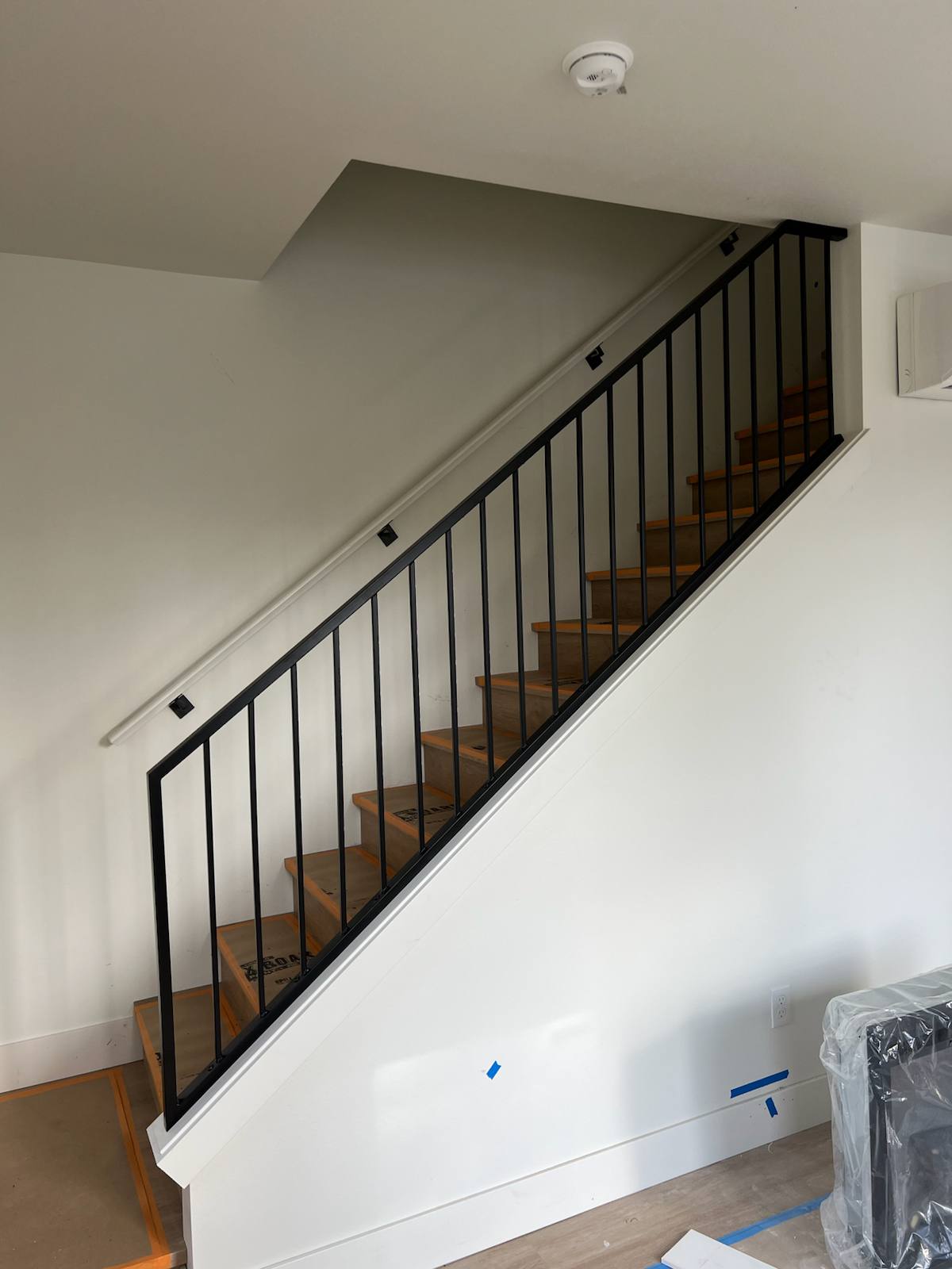 Black vertical-picket metal stair railing — measured, welded and installed on site