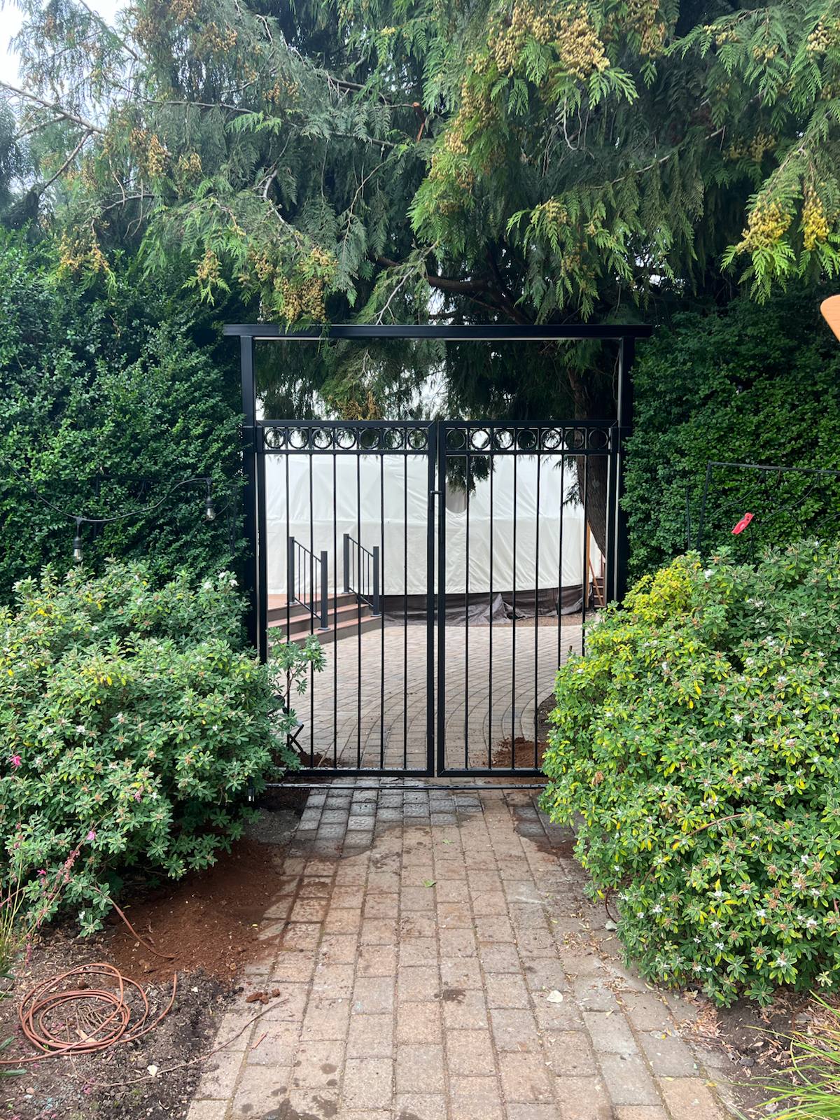 Black metal walk-through garden gate — welded and installed on site