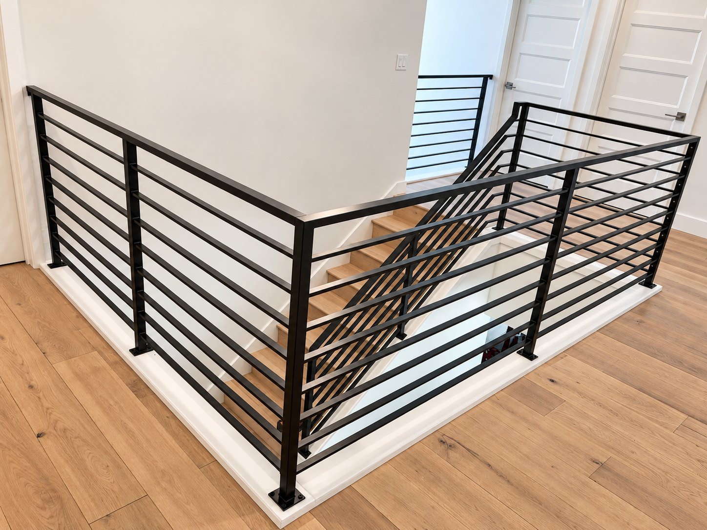 Modern horizontal-bar metal stair railing by Cascade Mobile Welding
