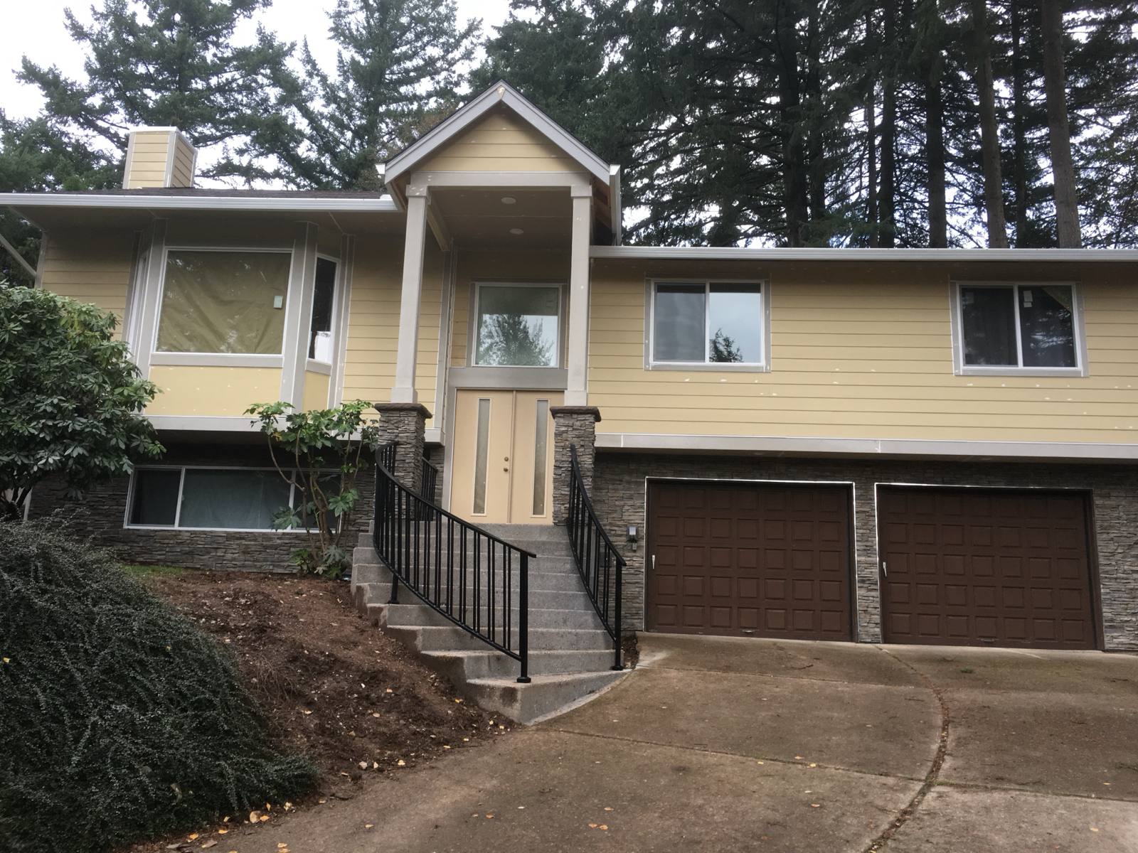 Black metal handrail on concrete front steps — custom metalwork, Portland