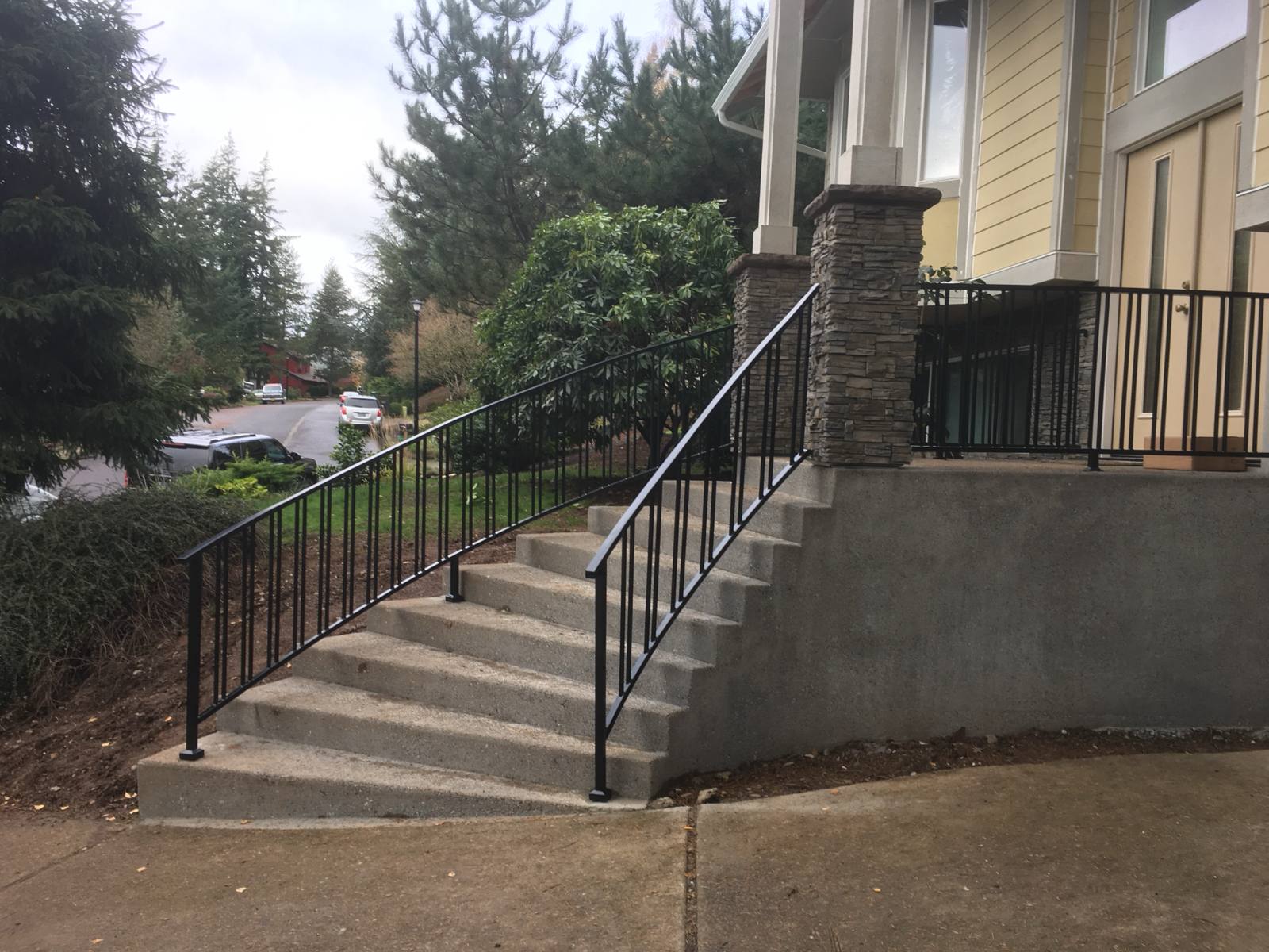 Black metal handrail on concrete front steps — Portland, OR