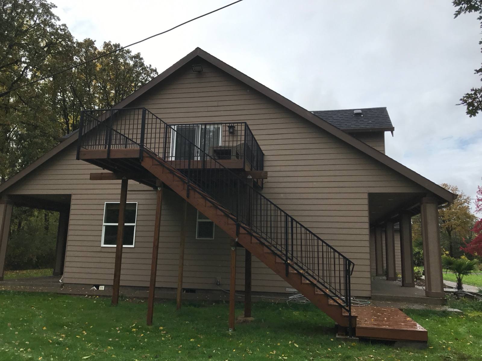 Metal railing on exterior deck stairs by Cascade Mobile Welding