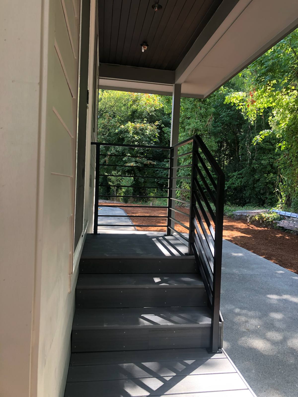 Black metal handrail on concrete front steps — welded and installed on site