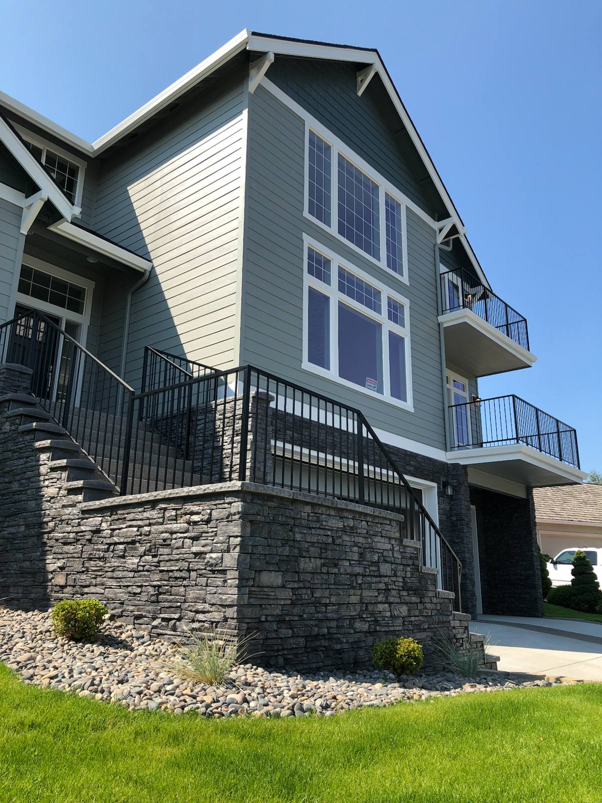 Black metal handrail on concrete front steps — welded and installed on site