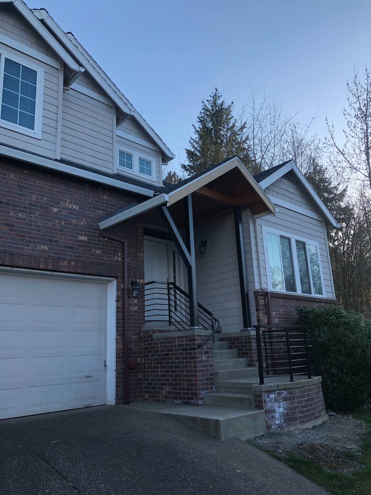 Black metal handrail on concrete front steps — custom metalwork, Portland