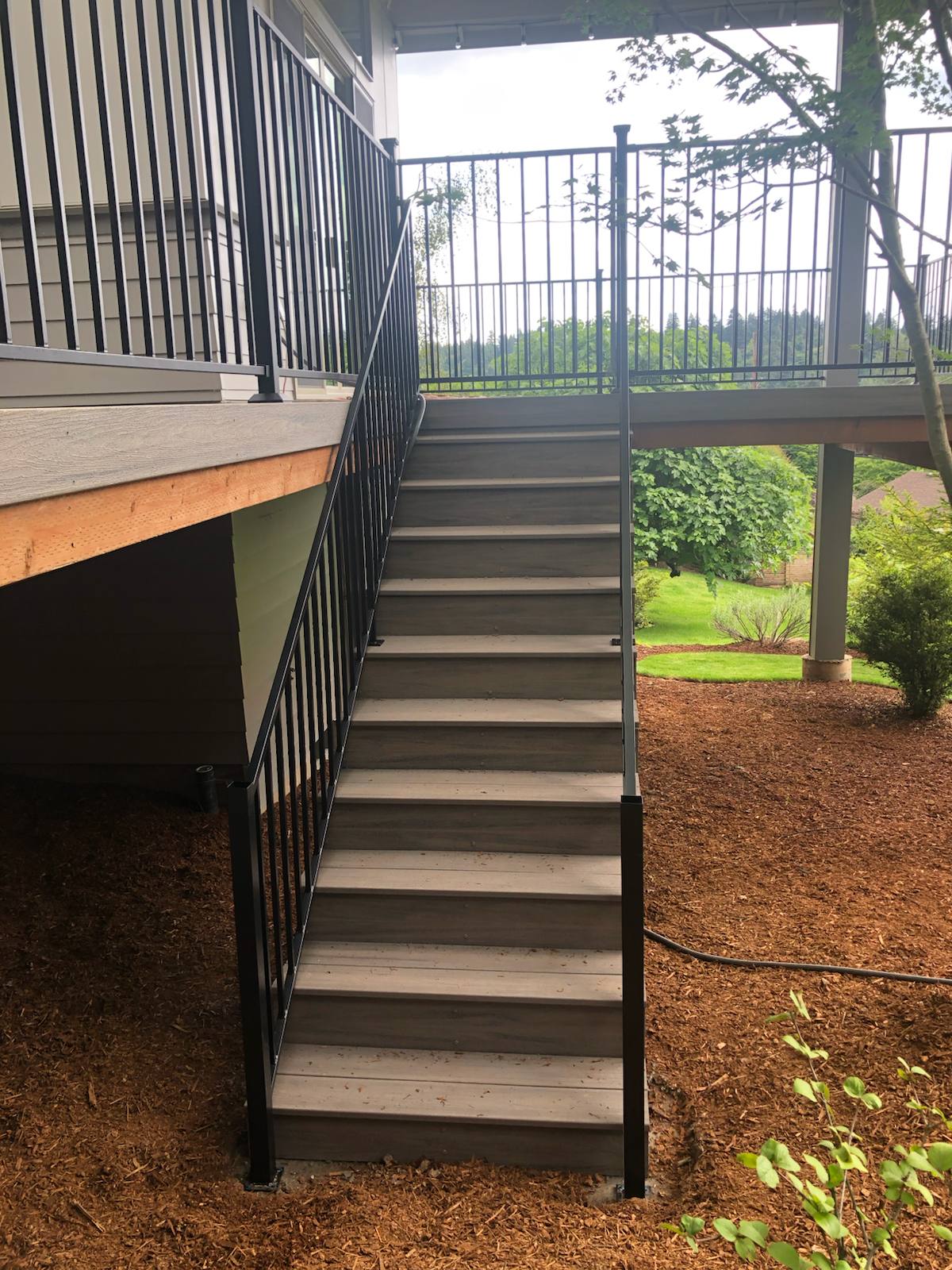 Metal railing on a multi-level exterior staircase by Cascade Mobile Welding