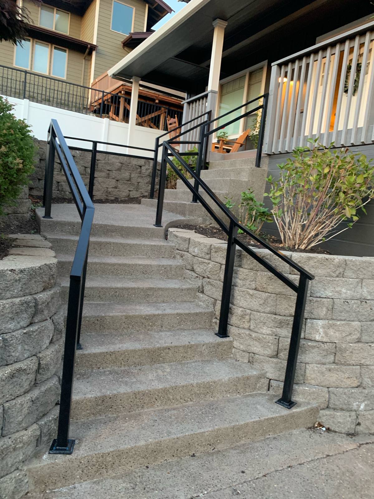 Metal handrail along an outdoor walkway and steps by Cascade Mobile Welding