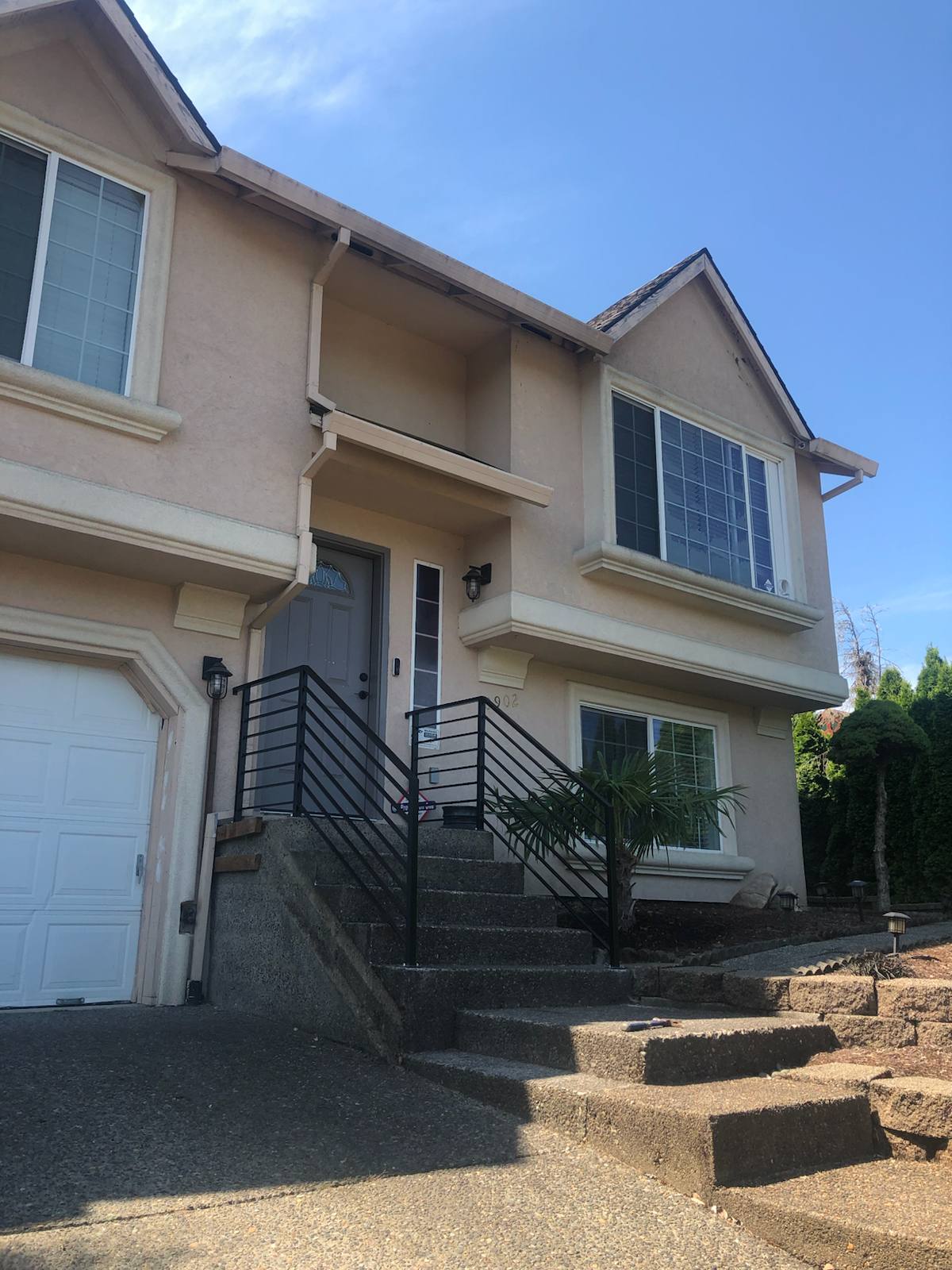Black metal handrail on concrete front steps in a Portland-area home