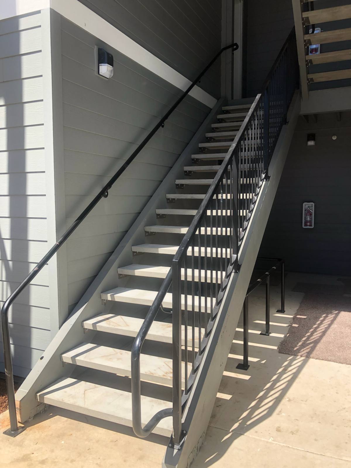Metal railing on a multi-level exterior staircase — welded and installed on site