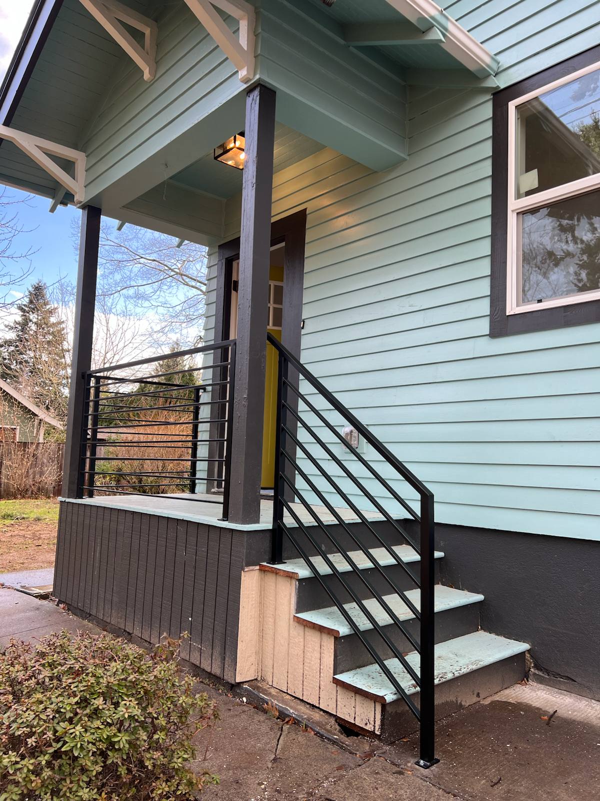 Black metal porch railing and step handrail — custom metalwork, Portland