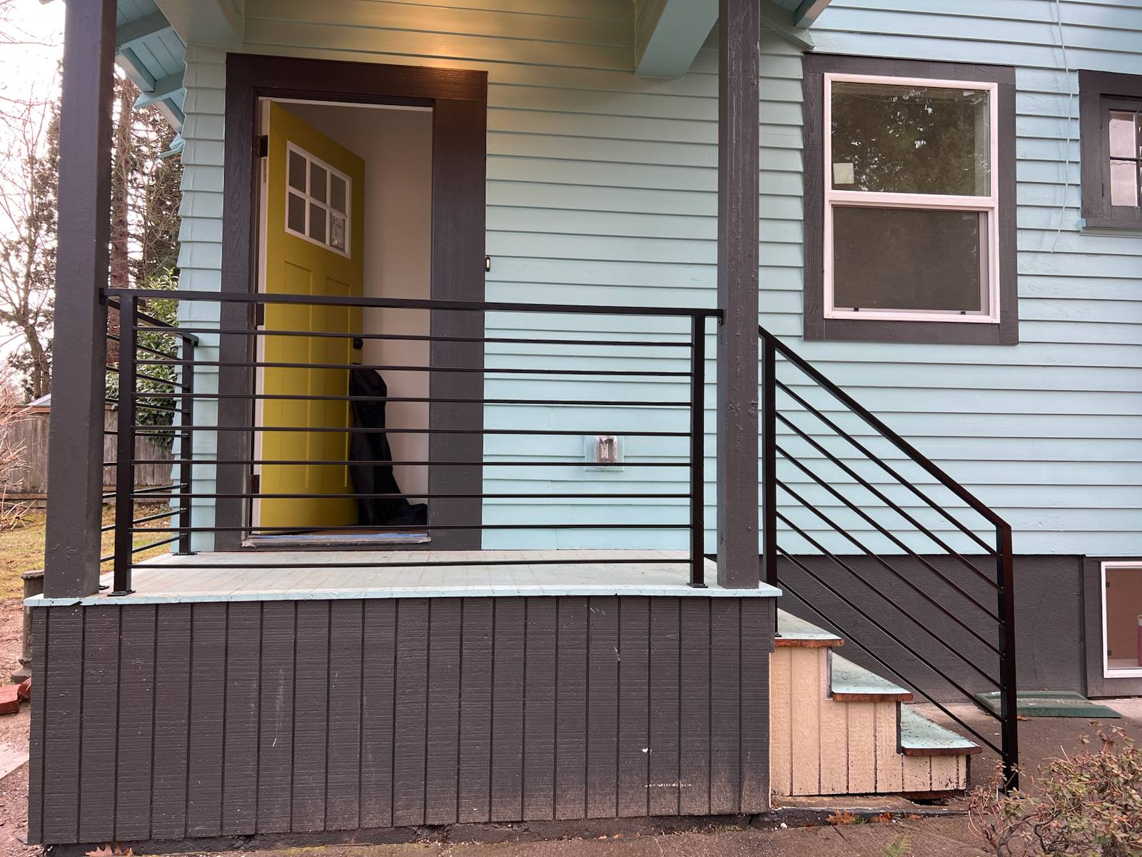 Black metal porch railing and step handrail in a Portland-area home