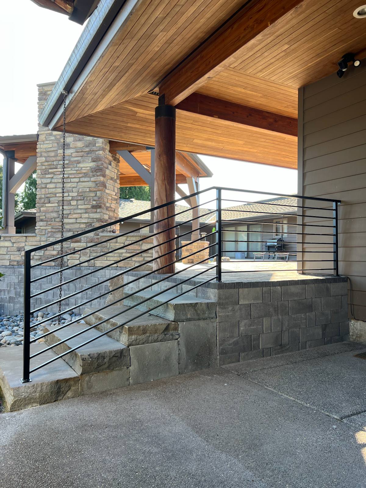 Black metal handrail on concrete front steps — welded and installed on site