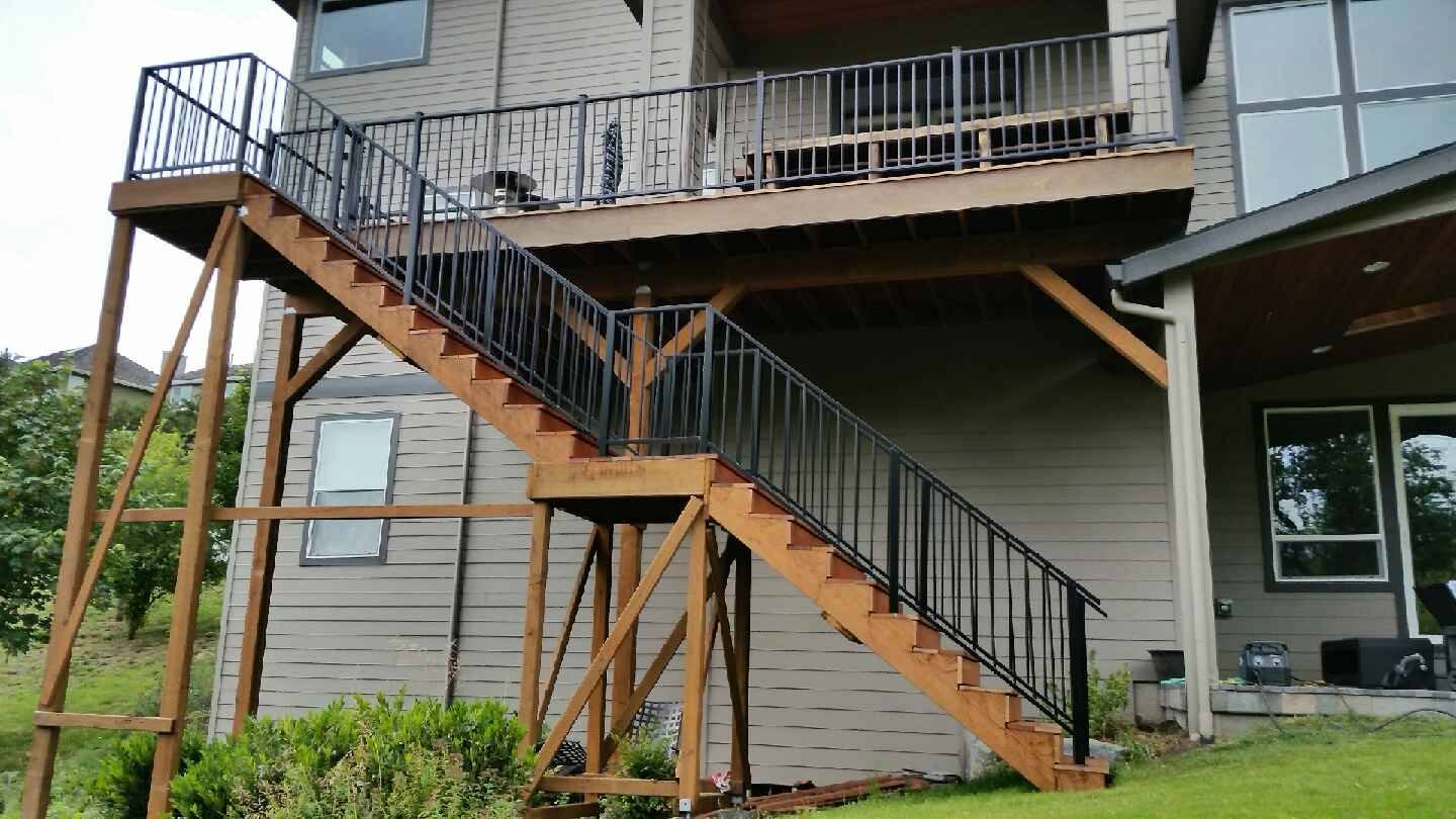Metal railing on exterior deck stairs by Cascade Mobile Welding